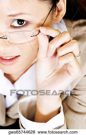 Stock Photo - Portrait of a businesswoman adjusting her eyeglasses. Fotosearch