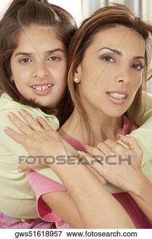 Stock Photo - Portrait of a daughter hugging her mother from behind. Fotosearch