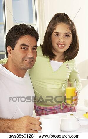 Portrait of a girl and her father holding a glass of juice View Large Photo Image Stock Image - Portrait of a girl and her father holding a glass of juice. Fotosearch