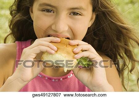 Portrait of a girl eating a burger View Large Photo Image Stock Photo - Portrait of a girl eating a burger. Fotosearch