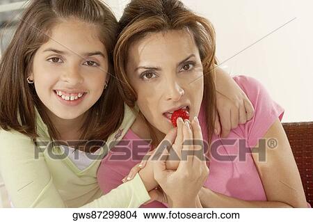 Portrait of a girl feeding her mother strawberries View Large Photo Image Picture - Portrait of a girl feeding her mother strawberries. Fotosearch