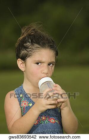 Portrait of a girl holding a baby bottle View Large Photo Image Stock Image - Portrait of a girl holding a baby bottle. Fotosearch