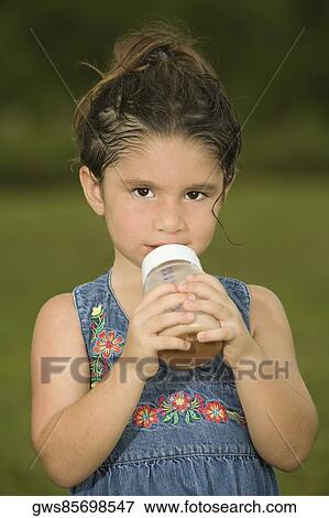 Portrait of a girl holding a baby bottle View Large Photo Image Stock Photo - Portrait of a girl holding a baby bottle. Fotosearch