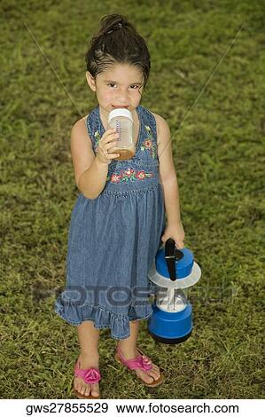 Stock Photo - Portrait of a girl holding a baby bottle and a lantern. Fotosearch