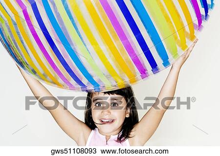 Portrait of a girl holding a ball over her head View Large Photo Image Stock Image - Portrait of a girl holding a ball over her head. Fotosearch