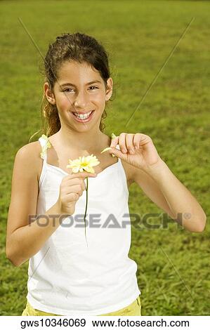 Portrait of a girl holding a flower View Large Photo Image Stock Photo - Portrait of a girl holding a flower. Fotosearch