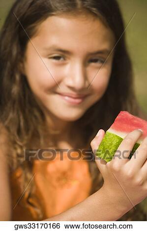 Portrait of a girl holding a slice of a watermelon View Large Photo Image Stock Photograph - Portrait of a girl holding a slice of a watermelon. Fotosearch