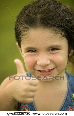 Portrait of a girl making a thumbs up sign View Large Photo Image Stock Image - Portrait of a girl making a thumbs up sign. Fotosearch