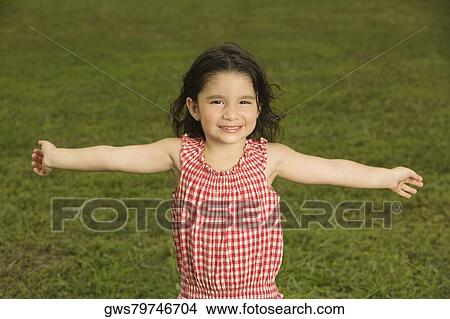 Portrait of a girl smiling with her arms outstretched View Large Photo Image Picture - Portrait of a girl smiling with her arms outstretched. Fotosearch