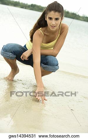 Portrait of a girl writing in sand with her finger View Large Photo Image Stock Image - Portrait of a girl writing in sand with her finger. Fotosearch