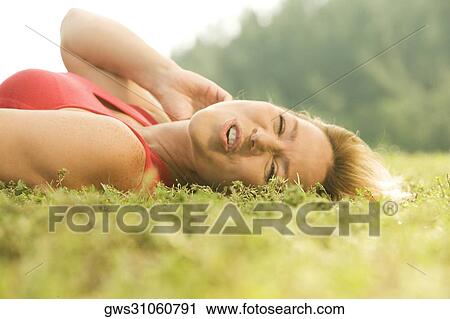 Portrait of a mature woman lying on the grass View Large Photo Image Stock Image - Portrait of a mature woman lying on the grass. Fotosearch