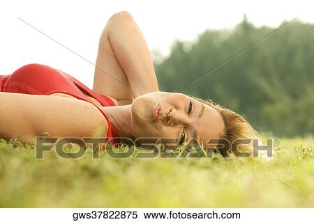 Stock Photography - Portrait of a mature woman lying on the grass. Fotosearch