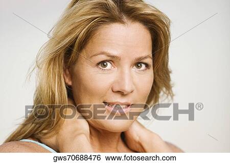 Stock Photograph - Portrait of a mature woman with her hands on her shoulders. Fotosearch