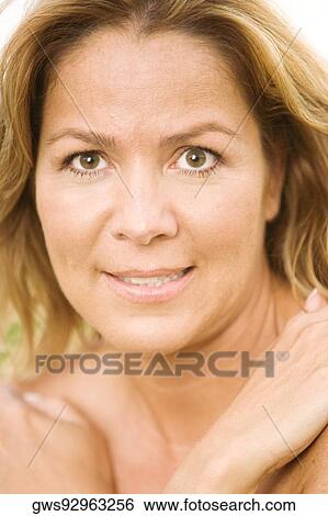 Stock Photograph - Portrait of a mature woman with her arms folded. Fotosearch