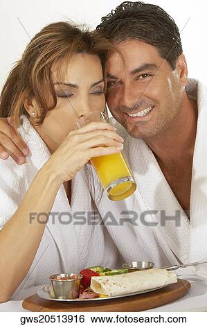 Portrait of a mid adult man and a mid adult woman drinking a glass of juice View Large Photo Image Stock Photograph - Portrait of a mid adult man and a mid adult woman drinking a glass of juice. Fotosearch
