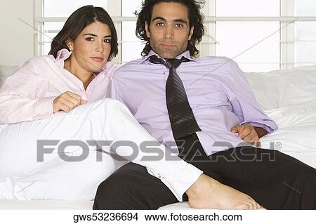 Picture - Portrait of a mid adult man and a young woman sitting on a couch. Fotosearch