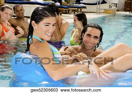 Portrait of a mid adult man and a young woman in a swimming pool View Large Photo Image Stock Image - Portrait of a mid adult man and a young woman in a swimming pool. Fotosearch