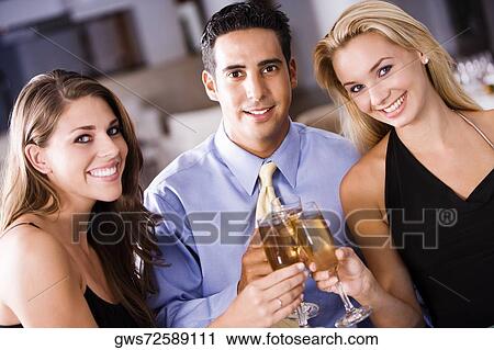 Portrait of a mid adult man and two young women raising a toast View Large Photo Image Stock Image - Portrait of a mid adult man and two young women raising a toast. Fotosearch