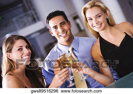 Portrait of a mid adult man and two young women raising a toast View Large Photo Image Stock Photograph - Portrait of a mid adult man and two young women raising a toast. Fotosearch
