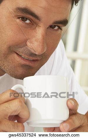 Portrait of a mid adult man holding a mug View Large Photo Image Picture - Portrait of a mid adult man holding a mug. Fotosearch