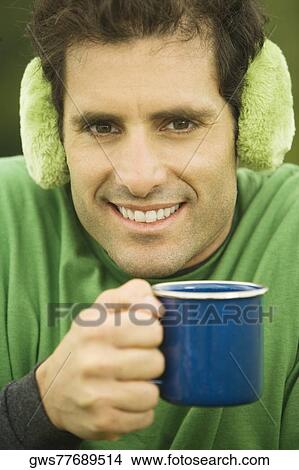 Portrait of a mid adult man holding a coffee cup smiling View Large Photo Image Picture - Portrait of a mid adult man holding a coffee cup smiling. Fotosearch
