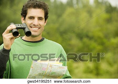 Portrait of a mid adult man holding a pair of binoculars and a map View Large Photo Image Stock Image - Portrait of a mid adult man holding a pair of binoculars and a map. Fotosearch