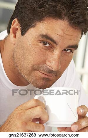 Portrait of a mid adult man holding a mug View Large Photo Image Stock Photo - Portrait of a mid adult man holding a mug. Fotosearch