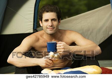 Portrait of a mid adult man holding a mug and a bun View Large Photo Image Stock Photo - Portrait of a mid adult man holding a mug and a bun. Fotosearch