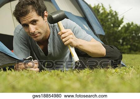 Portrait of a mid adult man putting up a tent View Large Photo Image Stock Image - Portrait of a mid adult man putting up a tent. Fotosearch