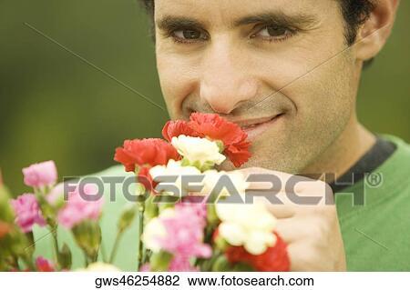 Portrait of a mid adult man smelling flowers View Large Photo Image Stock Image - Portrait of a mid adult man smelling flowers. Fotosearch