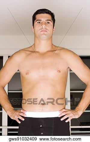 Stock Photo - Portrait of a mid adult man standing with arms akimbo. Fotosearch