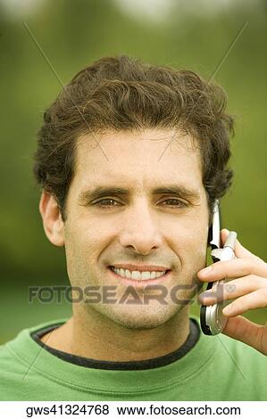 Stock Photo - Portrait of a mid adult man talking on a mobile phone. Fotosearch