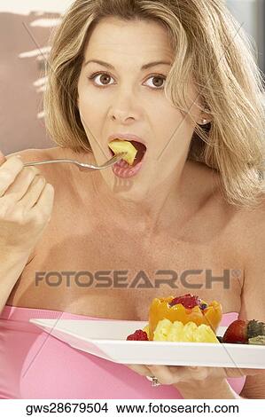 Portrait of a mid adult woman eating a papaya View Large Photo Image Picture - Portrait of a mid adult woman eating a papaya. Fotosearch