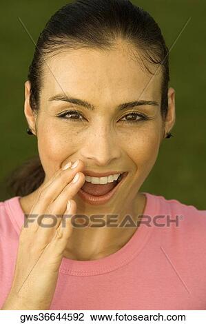 Portrait of a mid adult woman with her hand on her mouth View Large Photo Image Stock Image - Portrait of a mid adult woman with her hand on her mouth. Fotosearch