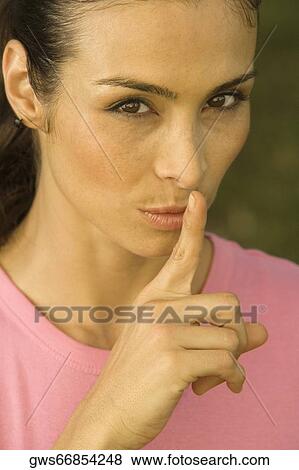 Portrait of a mid adult woman with her finger on her lips View Large Photo Image Stock Photo - Portrait of a mid adult woman with her finger on her lips. Fotosearch