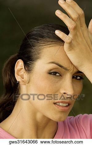 Portrait of a mid adult woman with her hand on her forehead View Large Photo Image Stock Photograph - Portrait of a mid adult woman with her hand on her forehead. Fotosearch