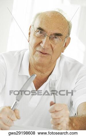 Portrait of a senior man holding a fork and a table knife View Large Photo Image Stock Photo - Portrait of a senior man holding a fork and a table knife. Fotosearch