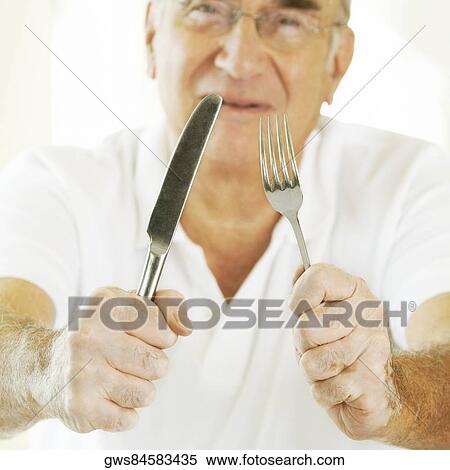 Portrait of a senior man holding a fork with a table knife View Large Photo Image Stock Photography - Portrait of a senior man holding a fork with a table knife. Fotosearch