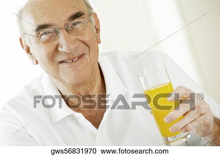 Portrait of a senior man holding a glass of juice View Large Photo Image Stock Image - Portrait of a senior man holding a glass of juice. Fotosearch