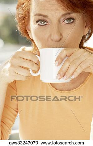 Stock Image - Portrait of a senior woman drinking a cup of coffee. Fotosearch