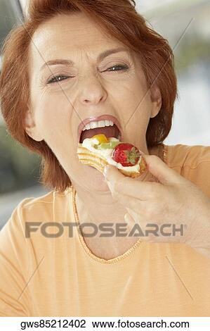 Portrait of a senior woman eating a fruit tart View Large Photo Image Stock Image - Portrait of a senior woman eating a fruit tart. Fotosearch