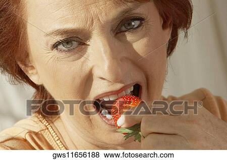 Portrait of a senior woman eating a strawberry View Large Photo Image Stock Photo - Portrait of a senior woman eating a strawberry. Fotosearch