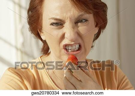 Portrait of a senior woman holding a strawberry View Large Photo Image Picture - Portrait of a senior woman holding a strawberry. Fotosearch