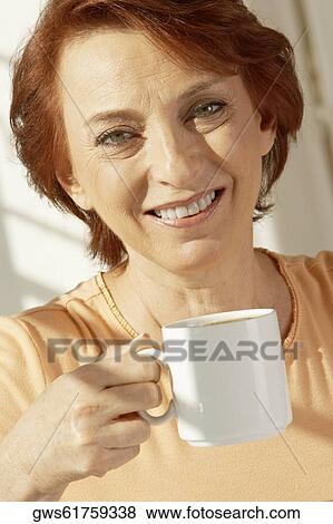 Portrait of a senior woman holding a coffee cup View Large Photo Image Stock Photo - Portrait of a senior woman holding a coffee cup. Fotosearch