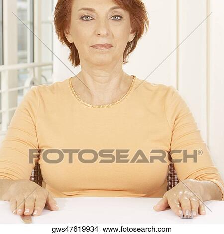 Portrait of a senior woman seated at the table View Large Photo Image Picture - Portrait of a senior woman seated at the table. Fotosearch