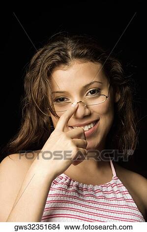 Portrait of a teenage girl adjusting her eyeglasses View Large Photo Image Picture - Portrait of a teenage girl adjusting her eyeglasses. Fotosearch
