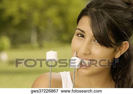 Portrait of a teenage girl eating marshmallow View Large Photo Image Stock Photo - Portrait of a teenage girl eating marshmallow. Fotosearch