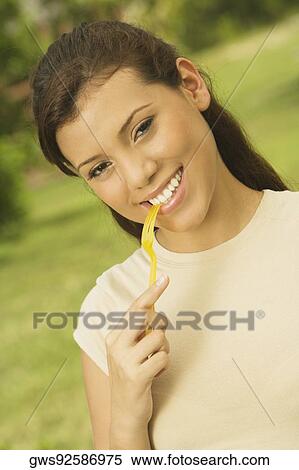 Portrait of a teenage girl holding a fork in her mouth View Large Photo Image Stock Photography - Portrait of a teenage girl holding a fork in her mouth. Fotosearch