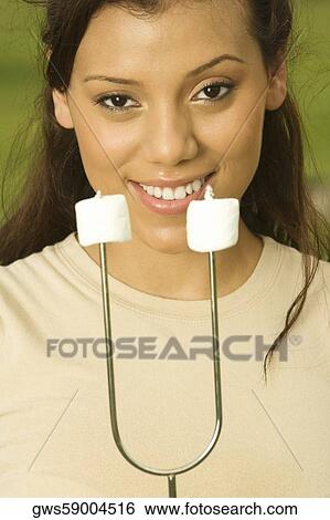 Portrait of a teenage girl holding marshmallows on a skewer View Large Photo Image Stock Photograph - Portrait of a teenage girl holding marshmallows on a skewer. Fotosearch