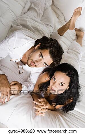 Portrait of a young couple lying on the bed View Large Photo Image Stock Image - Portrait of a young couple lying on the bed. Fotosearch